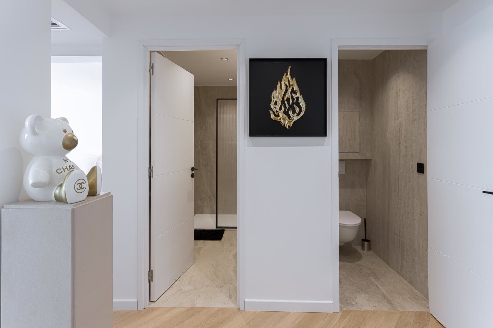 Entrée avec œuvre d'art, salle d'eau et WC séparés en travertin