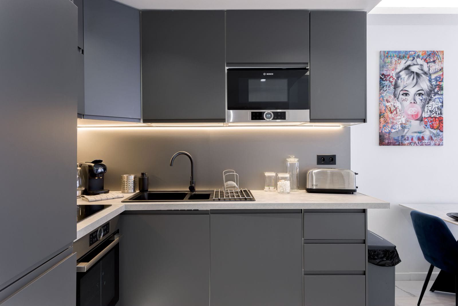 Électroménager Bosch encastré, plan de travail soigné et éclairage LED sous meubles.